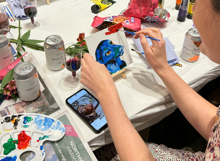 Top events in London today:  someone painting a mini canvas of a dog, using a photo on a phone as reference