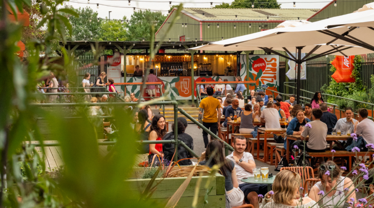 Things to do in London this bank holiday weekend:  people sitting at picnic tables in a beer garden