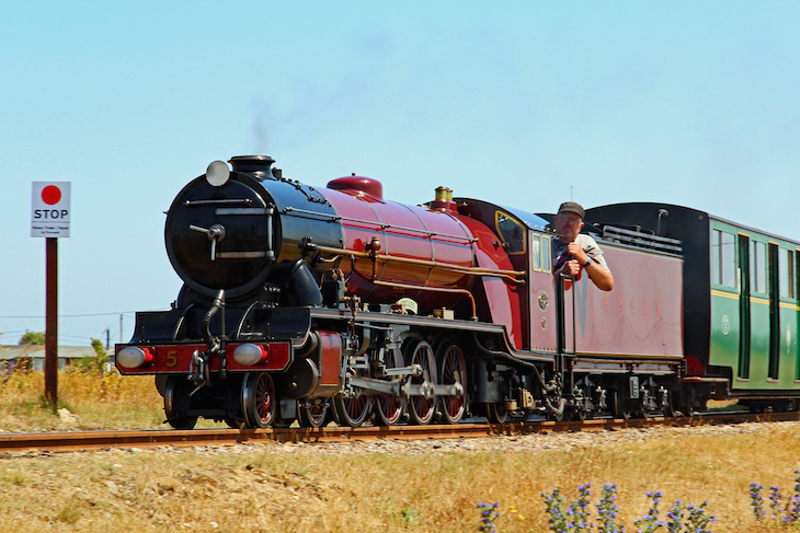 Seaside towns in Kent: a red steam engine heading through the countryside