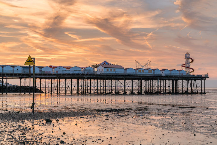 Kent's best beach towns: a pier jutting out into the sea at sunset