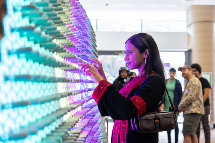 A young woman playing with colourful lights