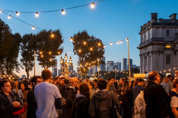 Things to do in London in summer 2026: crowds beneath fairy lights alongside the Royal Naval College at dusk