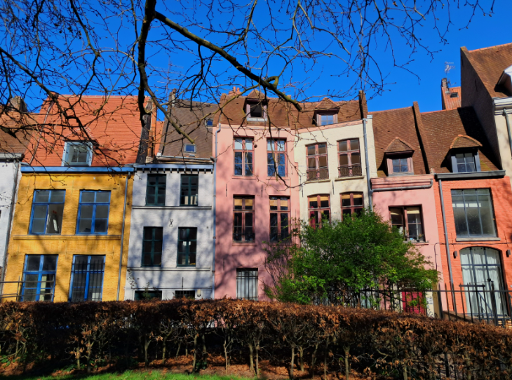 Day trip to Lille from London: a row of terraced houses painted in shades of pink, yellow, and orange
