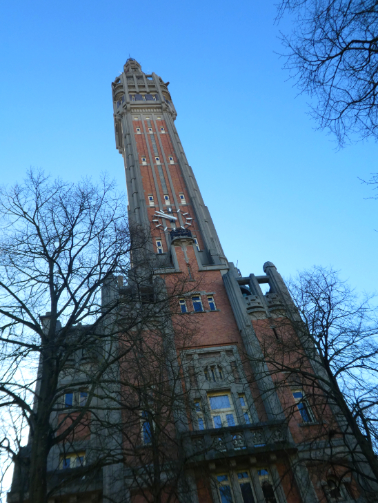 Extreme day trip from London to Lille: an ornate redbrick clock tower reaching up into a blue sky