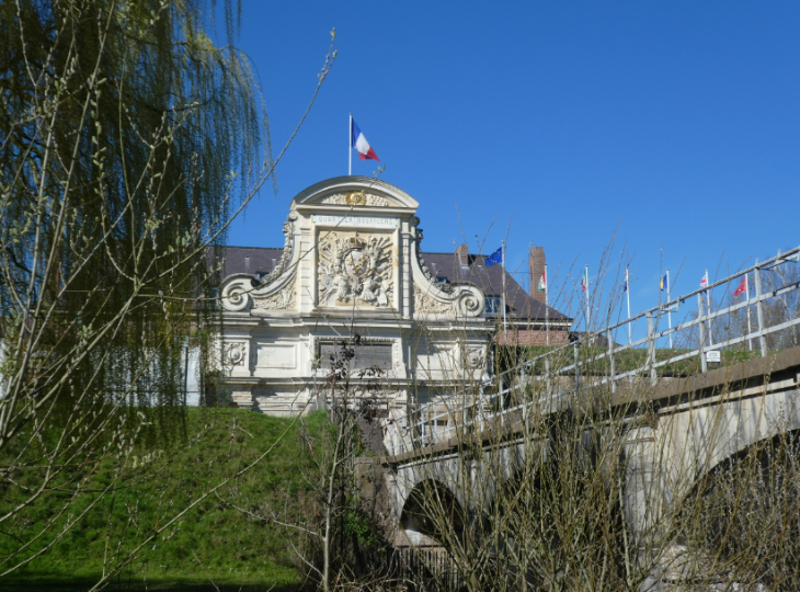 Extreme day trip from London to Lille:  a stone footbridge to an ornate building with the French flag