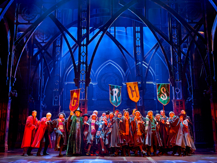 Best family/children's theatre shows in London for summer 2026: the cast of Harry Potter holding up banners with the letters G, R, H and S, representing the four houses of Hogwarts