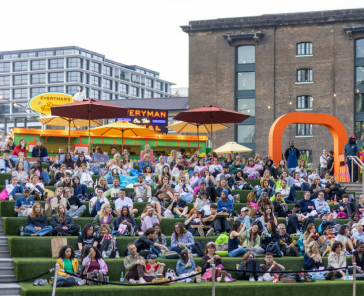 Free screenings of Wimbledon 2026 matches in London: people sitting on steps covered in fake grass alongside the canal