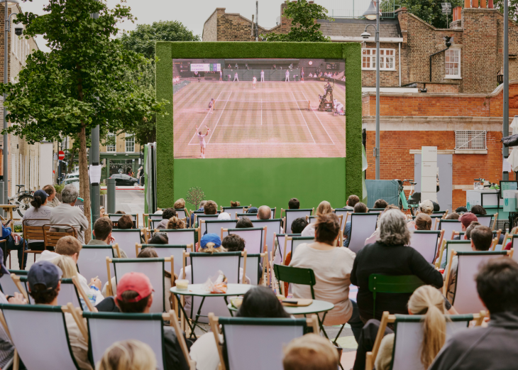 Free screenings of Wimbledon 2026 matches in London: people watching tennis on a large screen, from deckchairs