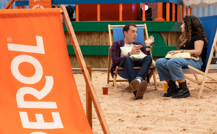 Beaches in London summer 2026: a man and woman sitting on deckchairs on a sandy beach in front of a bar