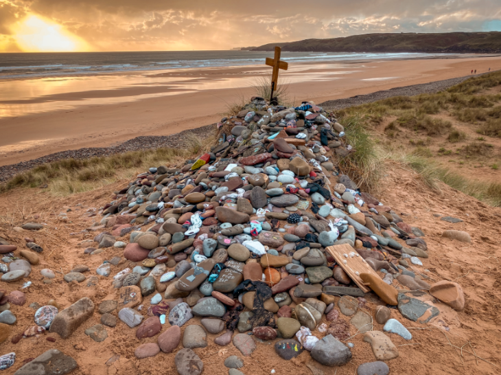 Top bank holiday weekend events London: a grave site on a beach, marked with a pile of stones and a wooden cross