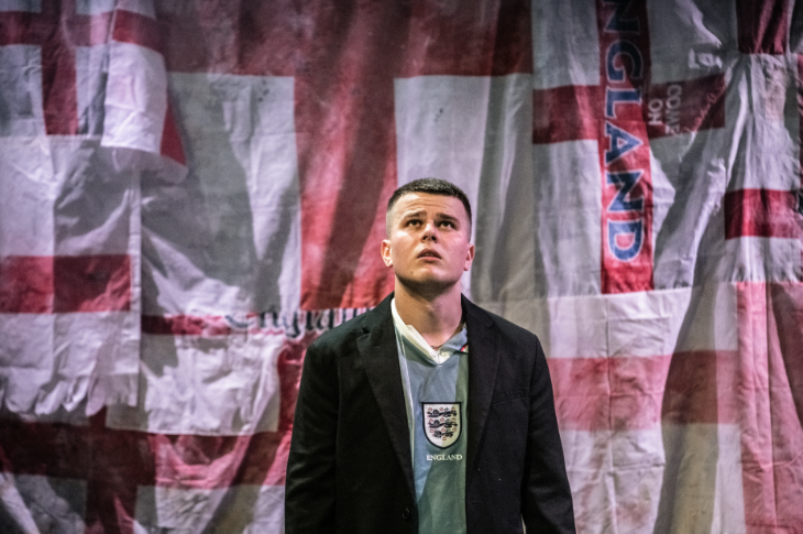 Things to do in London today:  a man in an England shirt and a jacket standing in front of a collage of England flags