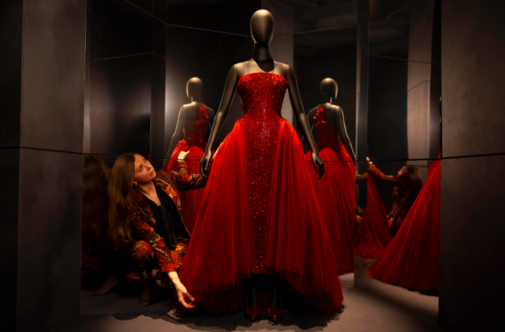 Top events in London today: a curator putting final touches to a display of a red ballgown