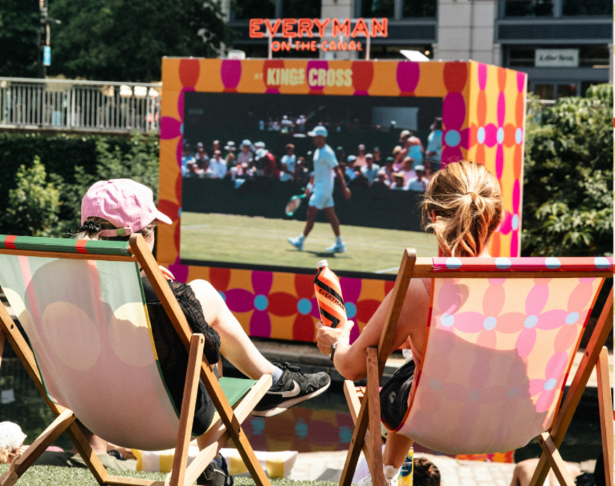 Free screenings of Wimbledon 2026 matches in London: people sitting in deckchairs watching a tennis match on a large open-air screen