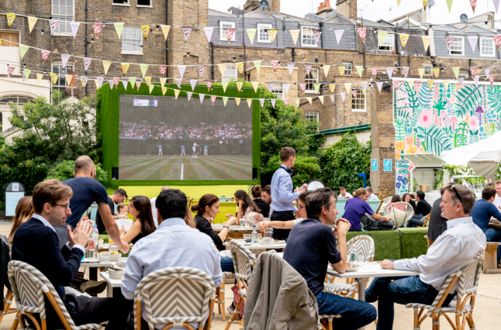 Free Wimbledon 2026 screenings London: 
 People sitting at tables in front of a large screen showing tennis