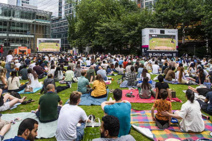 Free Wimbledon 2026 screenings London: people sitting on picnic blankets watching tennis on two large screens