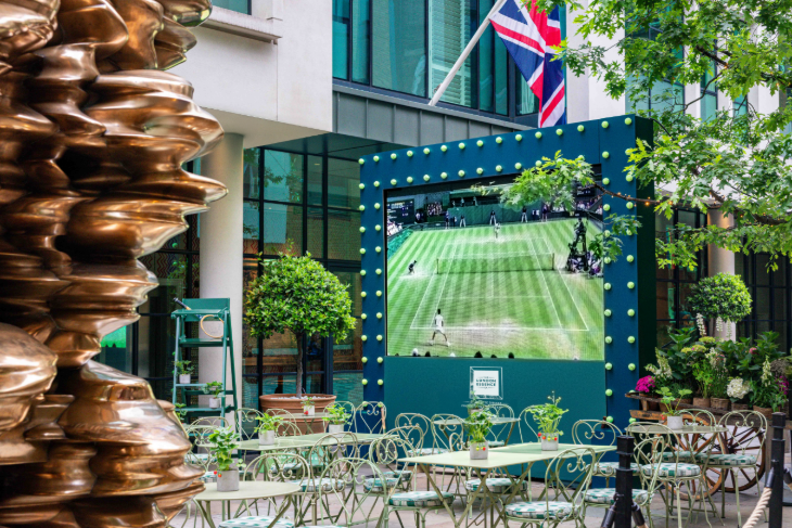 Free Wimbledon 2026 screenings London: tables and chairs set up in front of a large screen showing tennis