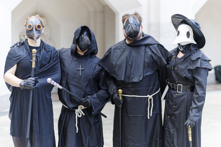 Four people in 17th century plaque doctor garb