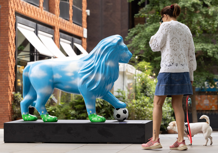 A woman with a dog studying one of the sculptures