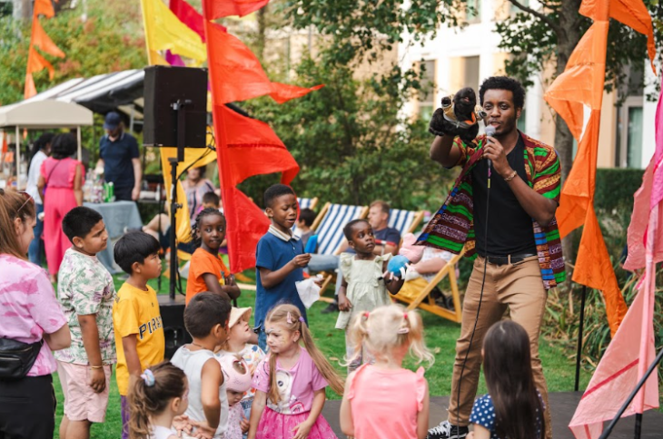 Free events in London this week: a man with a puppet entertaining a small group of children at a fete