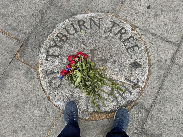 A top-down view of a circular stone plaque on a sidewalk inscribed with 
