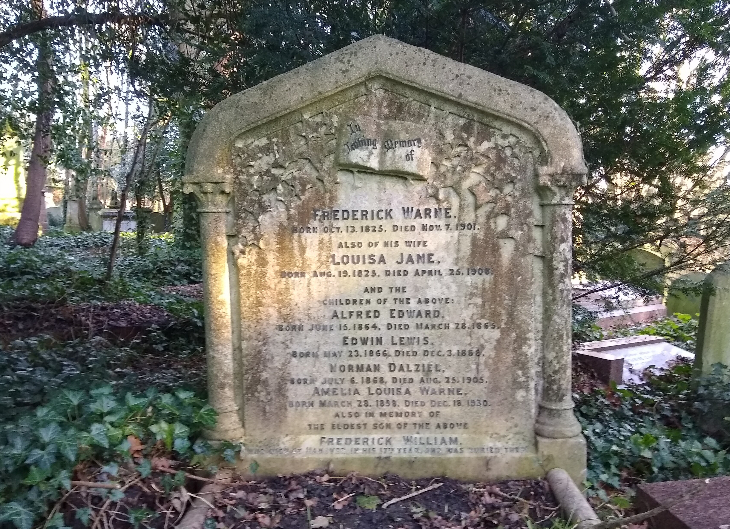 Beatrix Potter's London: A weathered stone headstone for Frederick Warne and his family stands in a wooded cemetery, surrounded by ivy and fallen leaves. The inscription lists Frederick, his wife Louisa Jane, and several of their children.