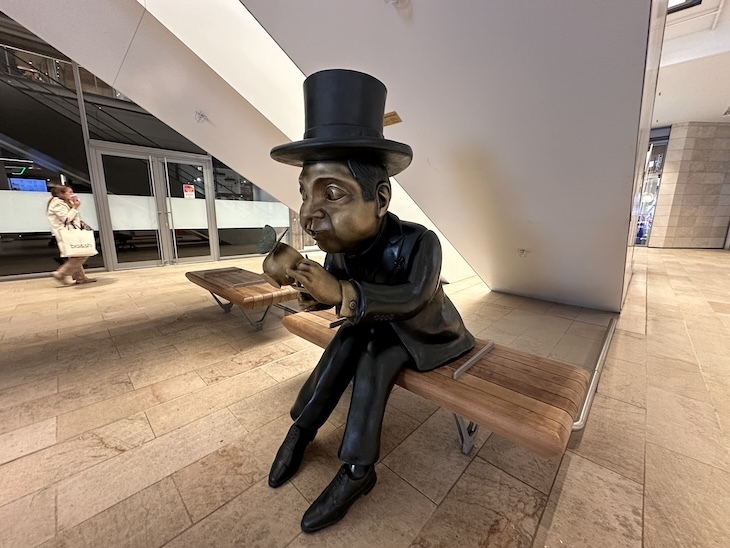 A bubbly gent sculpture under an escalator