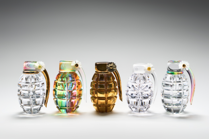 A row of five grenades made of glass, each the same size and design but in different colours