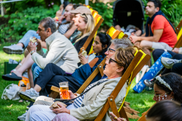 Things to do in London today: people sitting in deckchairs on grass, with a drink in hand