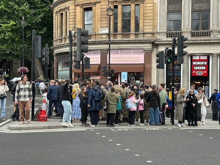 A traffic island crowded with people near Trafalgar Square