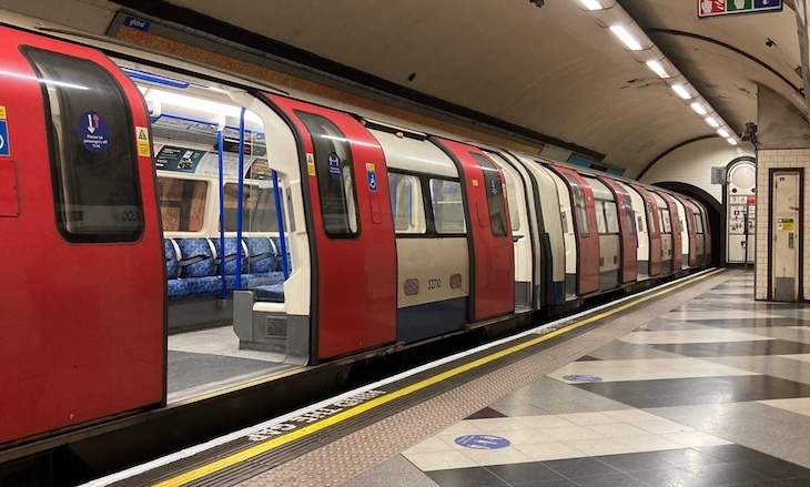 A modern tube train at a platform with its doors open. No people can be seen onboard
