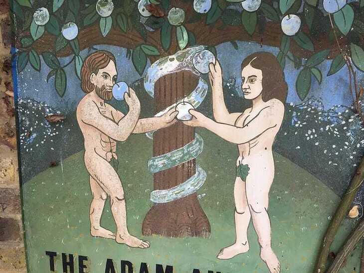 Adam and eve very badly painted on a hanging pub sign