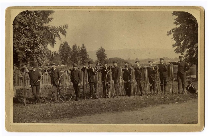 A row of men with penny farthings
