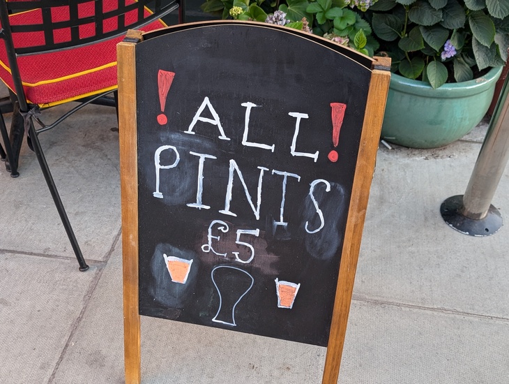 A chalkboard advertising £5 pints