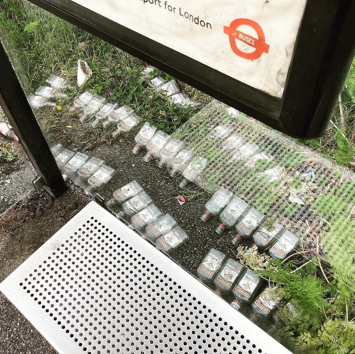 Neat rows of vodka bottles at a bus stop.
