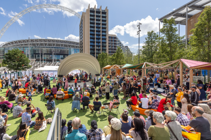 Things to do in London this weekend: people sitting on deckchairs and fake grass in front of a stage, which itself is in front of Wembley Stadium