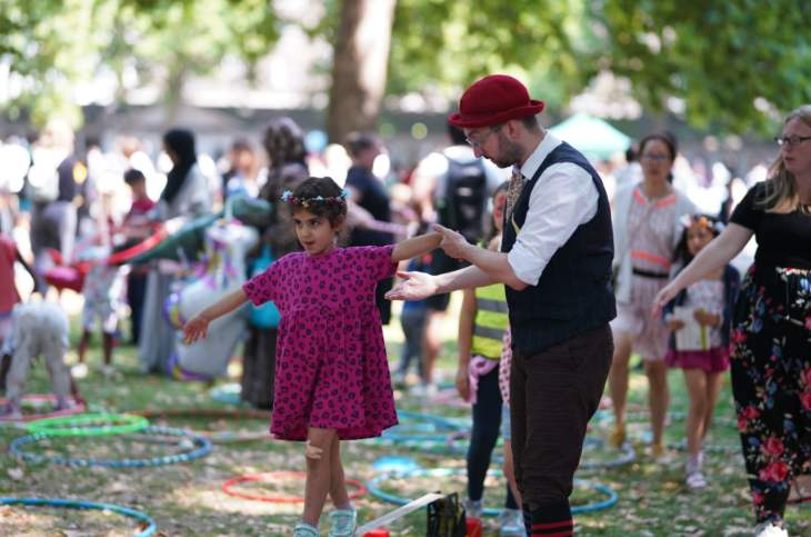 A man helping a young girl walk along a beam