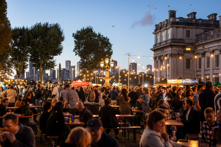 Things to do in London today: an open-air bar/street food area beneath fairy lights outside the Royal Naval College in Greenwich at dusk