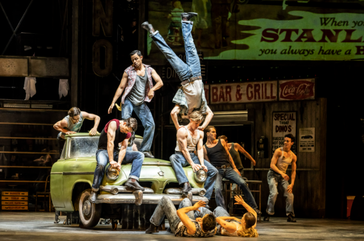 Things to do in London today: cast members of The Car Man on stage, sitting and standing around the front half of a car