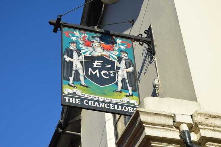 A pub sign for the Chancellors showing two Tudor teaches pointing at Einstein's equation