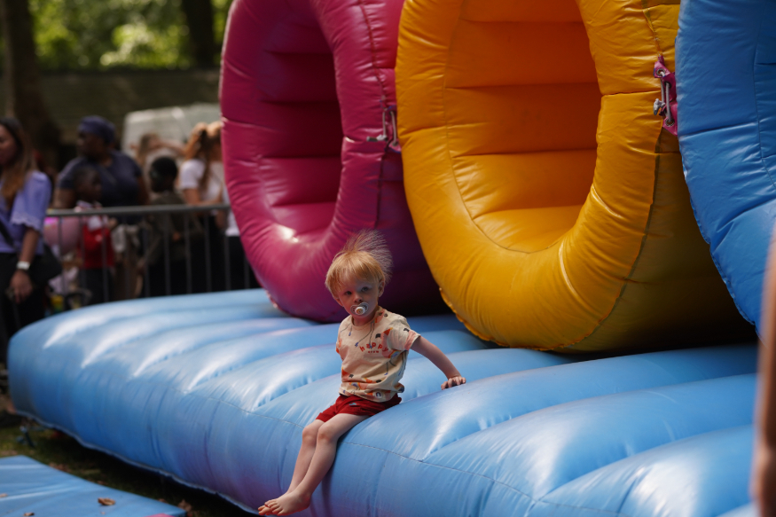 A toddler sitting on the edge of a bouncy castle