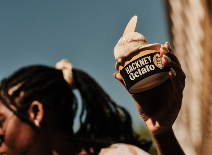 A person holding up a cup of Hackney Gelato ice cream