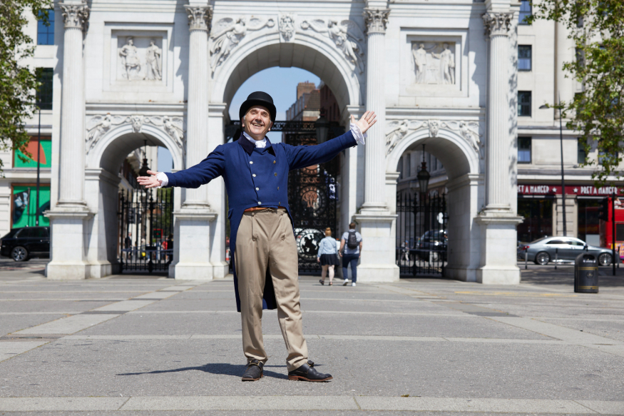 A person dressed as John Nash posing in front of Marble Arch