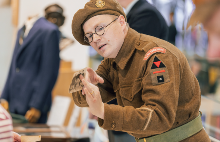 A person in a military uniform examining an artefact