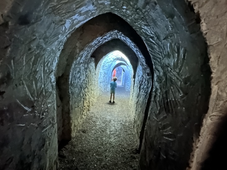 A boy in a long cave tunnel