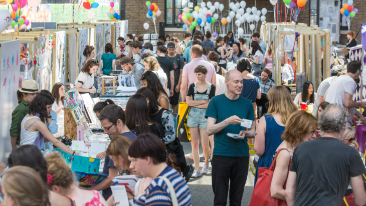 People walking among stalls at the Illustrators' Fair