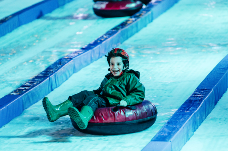 Hyde Park Winter Wonderland Christmas 2026 guide: a child riding down an ice slide on an inflatable ring