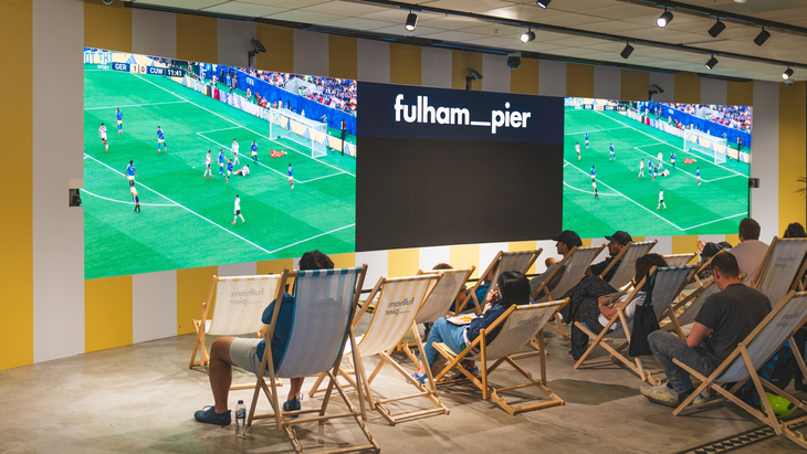 People watching football on the big screen on deck chair
