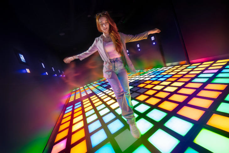 a woman crosses an illuminated floor