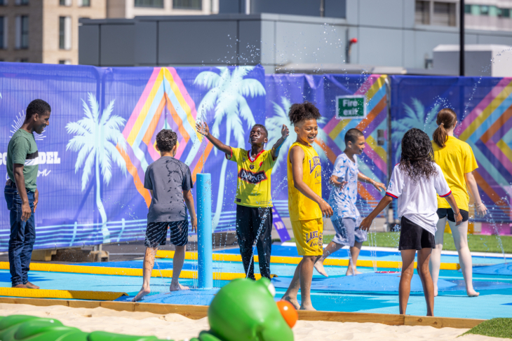 Children and teenagers playing in play fountains
