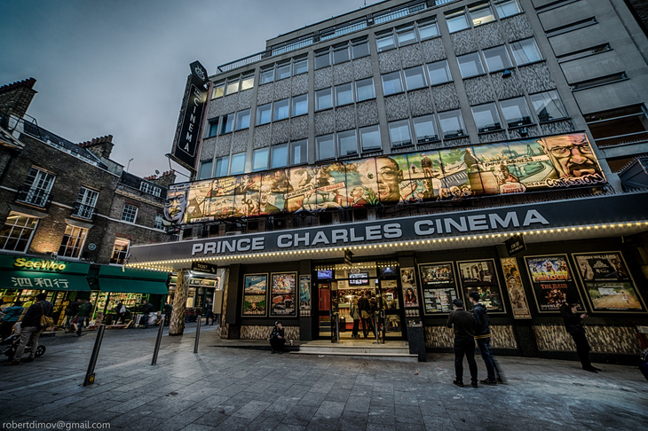 Halloween 2026 film screenings London: A wide-angle, low-angle shot of the Prince Charles Cinema in London at dusk, featuring a large Breaking Bad mural above the marquee and several movie posters displayed along the ground floor.